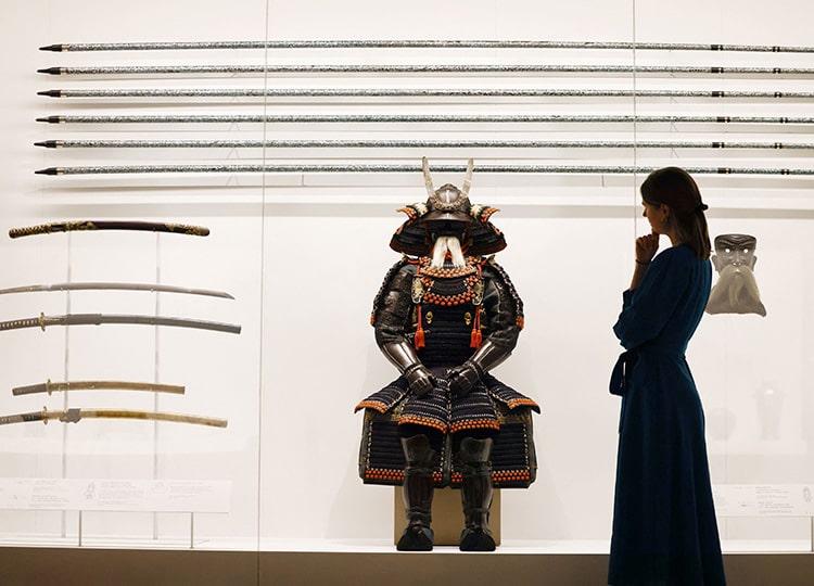 日本から寄贈された甲冑を眺める王室美術館の職員