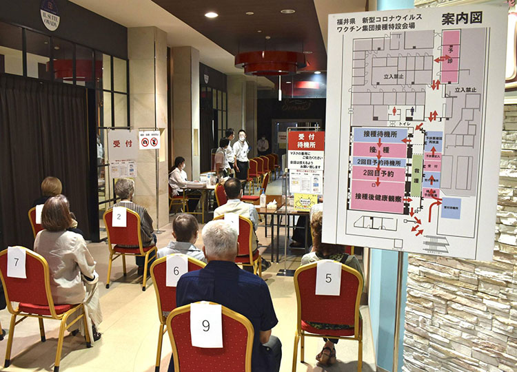 People wait to get vaccinated against COVID-19 at a mass inoculation site at a shopping mall in the city of Fukui in June.