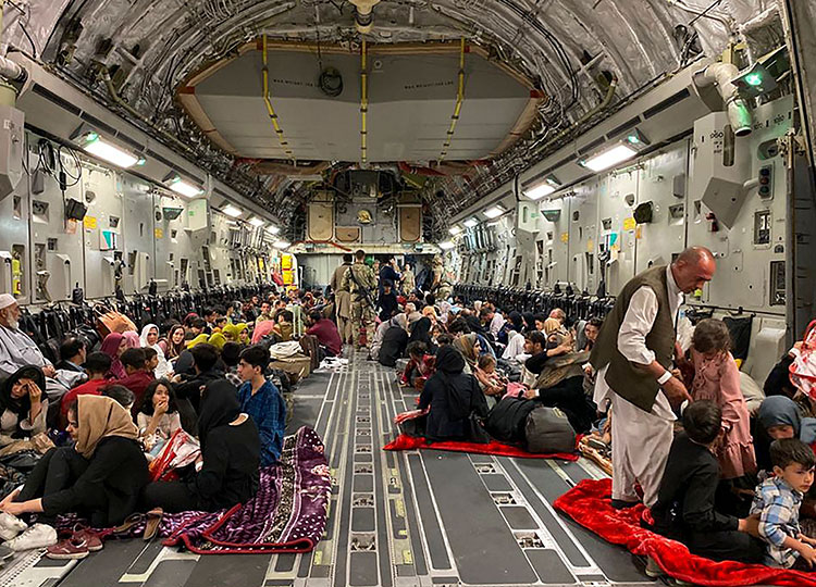 Afghan people wait inside a U.S. military aircraft to leave Afghanistan, at the military airport in Kabul on Aug. 19, 2021, after Taliban’s military takeover of Afghanistan.