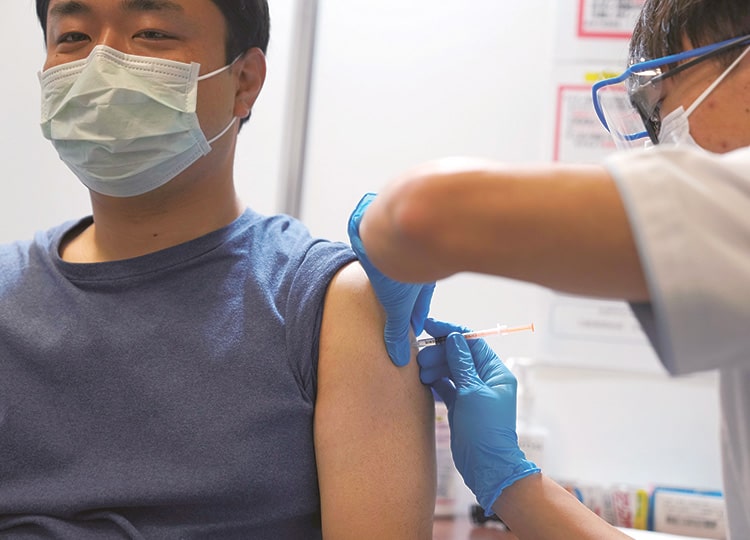 A local resident receives the booster shot of the Moderna coronavirus vaccine at a mass vaccination center in Tokyo on Jan. 31.