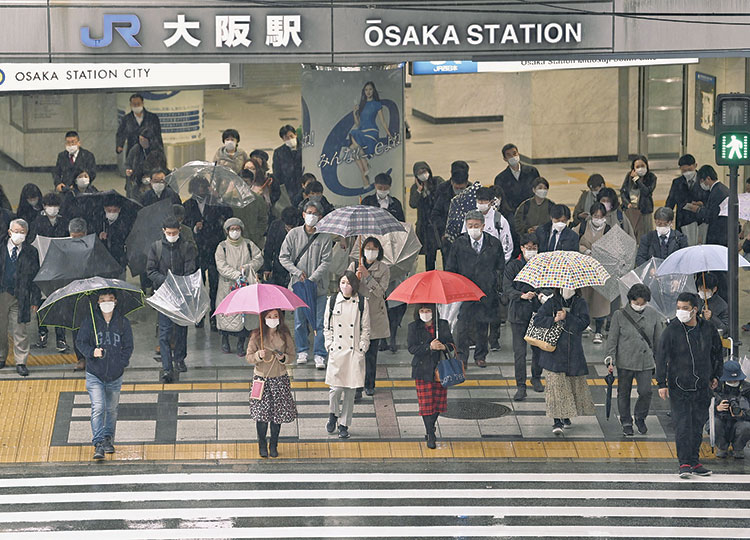 People at a pedestrian crossing in Osaka early on March 22, the day the COVID-19 quasi-state of emergency ended.