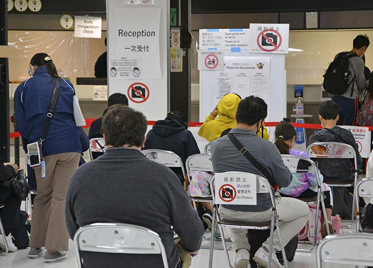 国際線到着後、成田空港で待機する人々